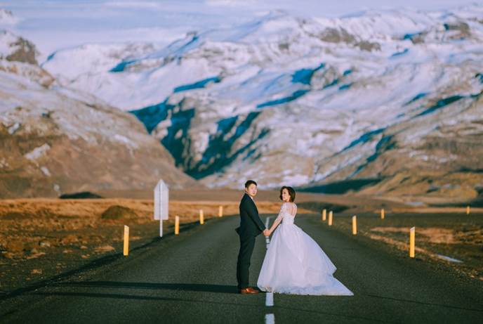 公路尽头雪山 情侣婚纱走在无人公路上